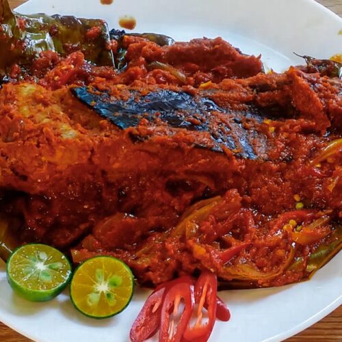 Close up of the grilled stingray that is cooked on a white plate.